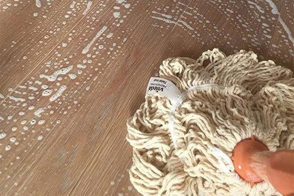 Photo of wood flooring being cleaned with WOCA Natural Soap and cotton swep mop.